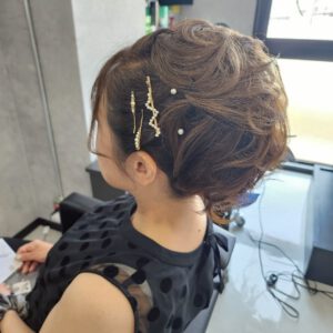 ゴールドのヘアピンとパールを飾った、カールたっぷりのボリュームアップスタイル