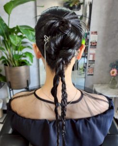 三つ編みを組み合わせて後ろでまとめた黒髪の編み下ろしアップスタイル