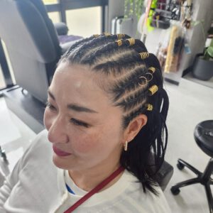 サイドまでしっかり編み込んだタイトなコーンロウ。黒髪に映える立体感あるラインデザイン。