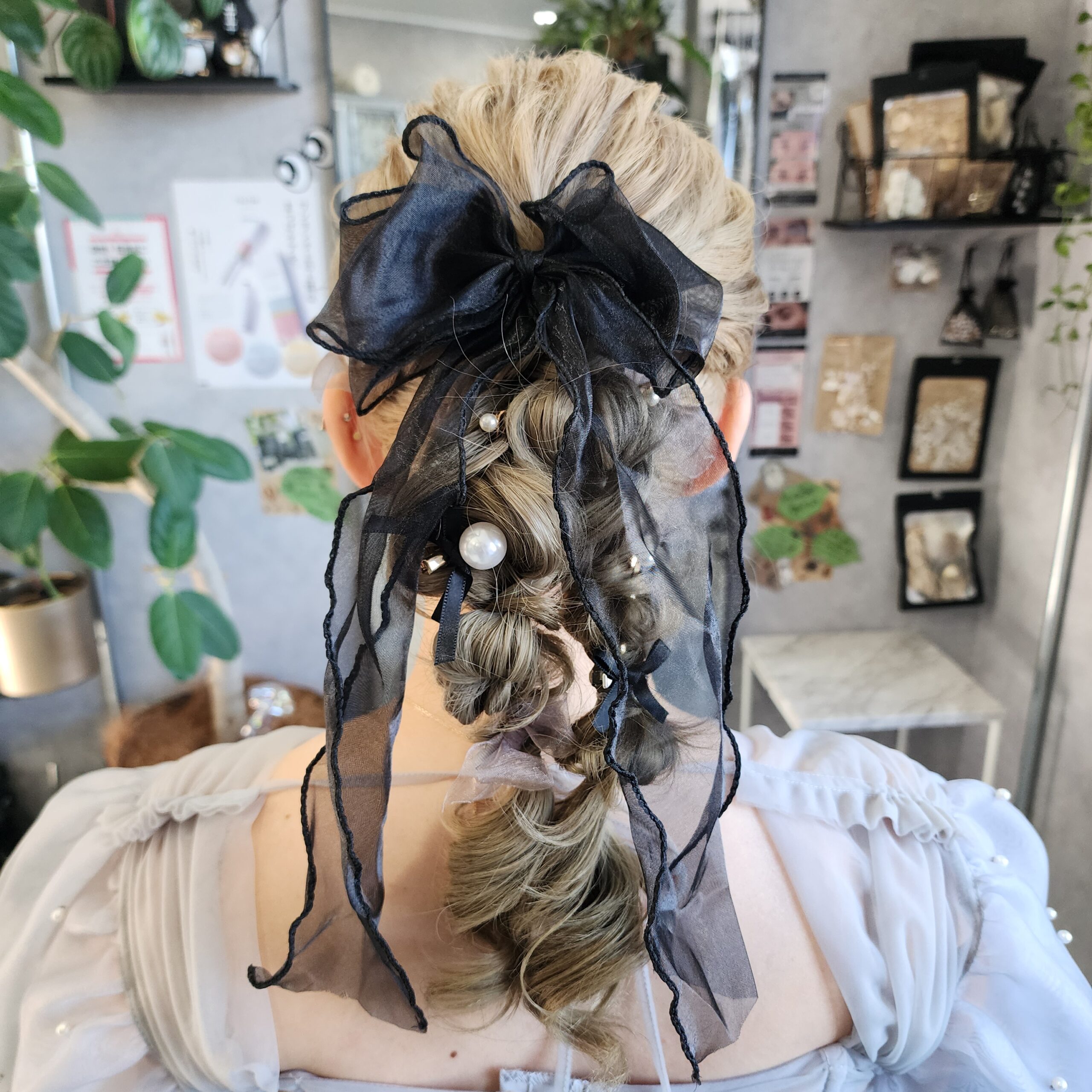 透け感のある大きなブラックのリボンを主役にした、非常にデコラティブで華やかな編みおろしスタイルです。