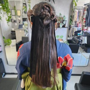 卒業式の袴スタイルに最適な、ロングリボンのハーフアップアレンジ。編み込みでボリュームを出したトップに、トレンドのロングリボンとパールを配置。面の艶を活かしたストレート部分とのコントラストが美しい、クラシックかつモダンなヘアセットです。