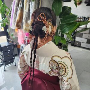 立体的なまとめ髪と細かな編み下ろしを組み合わせたヘアセットと、美しく整えられた袴の着付け技術