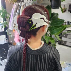 ボルドーカラーの艶を活かした和洋折衷なシニヨンスタイル。大胆なカラー（花）の配置と、パールのアクセントがモードな印象を与えます。成人式やパーティーで個性を出したい方に最適な、エッジの効いたヘアセットです。