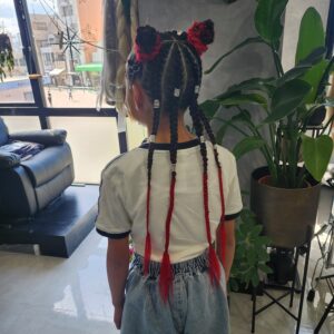 ​赤と黒の派手髪エクステンションを編み込んだキッズコーンロウとスペースバンズのヘアアレンジ。ビーズカフス付きのロングスタイル。