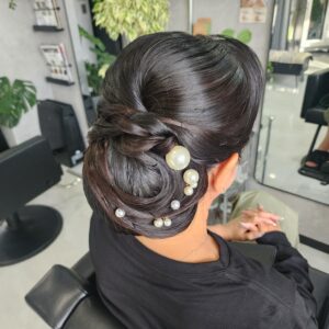 面と艶を出した和装ダウンシニヨンスタイル。シニヨンの表面は立体的にデザインされパールのアクセサリーが上品さをプラスしている。
